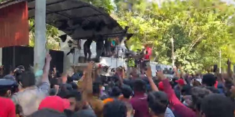 අරගලකරුවෝ මහින්දගේ ගෙදර තාප්ප උඩ නැග කලු කොඩි උස්සයි! බැනර් ගහයි! සජීවී වීඩියෝව මෙන්න! (VIDEO)