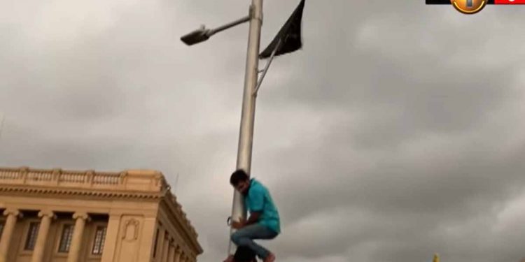 දහස් ගණනකගේ ජයඝෝෂා මැද කොල්ලෙක් ජනපති ලේකම් කාර්යාලය ඉදිරිපිට කණුවක කලු කොඩියක් ඔසවයි! (VIDEO)