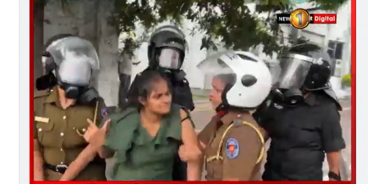 දහස් ගාණක් පාරට බැහැලා උද්ඝෝෂණ කරද්දි කෙල්ලෙක්වයි කකුල් දෙකම නැති ආබාධිත සෙබළෙකුයි අල්ලගෙන ‌පොලිසිය පාර මැද්දෙ කරපු යුද්ධයක්! (VIDEO)