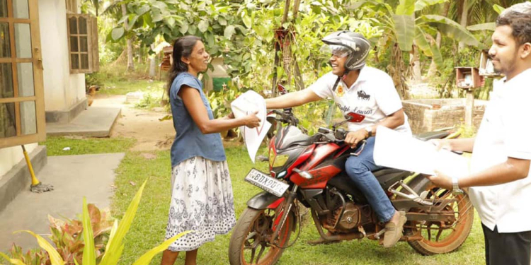 රාජ්‍ය ඇමැති සනත් නිශාන්ත බයික් එකෙන් පුත්තලමේ ගෙවල්වලටම ගිහින් නොමිලේ ලිතක් දෙයි! PHOTOS